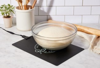 Bowl of bread dough proofing on dough riser