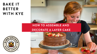 Kye using strawberries to garnish a chocolate layer cake